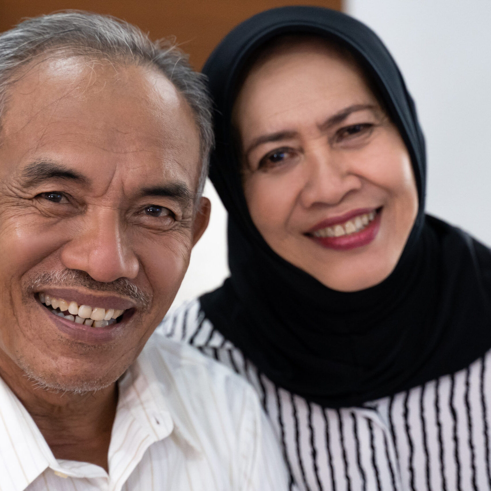 Asian,Senior,Muslim,Couple,Sitting,On,The,Sofa,And,Smiling